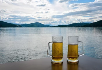 Crédence de cuisine en verre imprimé Denali two glasses of beer on the table overlooking the alpine lake 