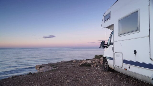 Camper vehicle camping by sea. Traveling by motorhome. Caravan vacation. Nature and activities.