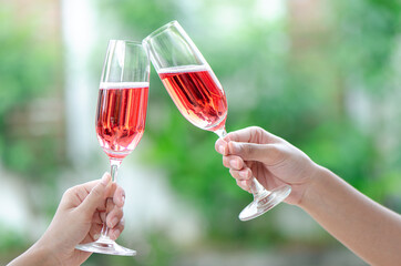 two person holding two glasses of red wine at a celebration dinner