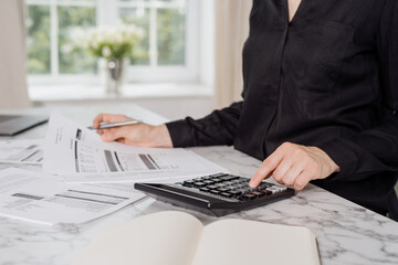 Woman using black calculator to calculate payments