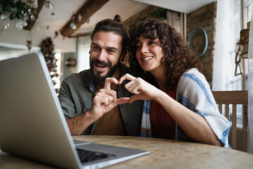 Smiling young couple making a video call with family at home. People technology happiness concept