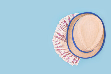 Lots of Ukrainian hryvnias and a hat on a blue background
