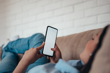 Young woman using smartphone while on the couch at home