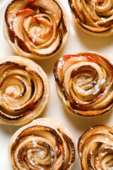 Freshly baked apple roses on light background, flat lay. Beautiful dessert