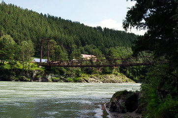 Fototapeta na wymiar suspension bridge over a mountain river. nature of mountain Altai