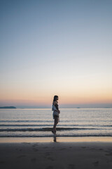 Naklejka premium 夕暮れの海にいる女性