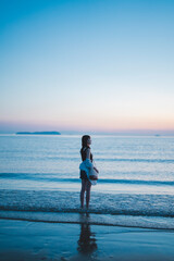 Fototapeta premium 夕暮れの海にいる女性