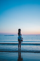 Fototapeta premium 夕暮れの海にいる女性