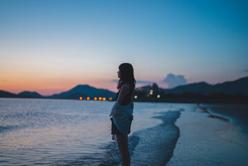 夕暮れの海にいる女性