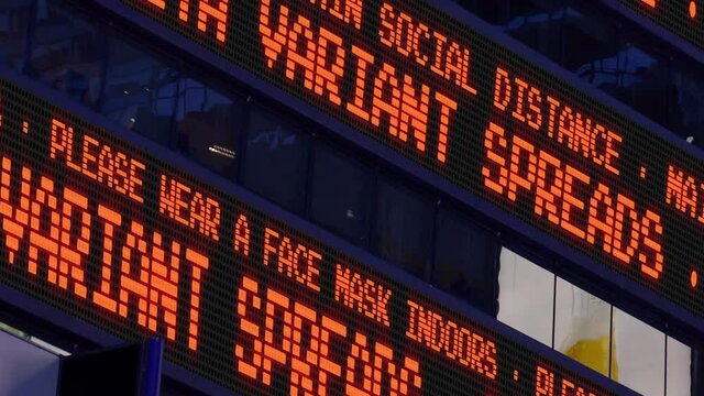 A fictional stock market ticker informs pedestrians about the Delta Variant strain. Masks and social distancing were common practices to slow down the spread of coronavirus during the pandemic of 2021