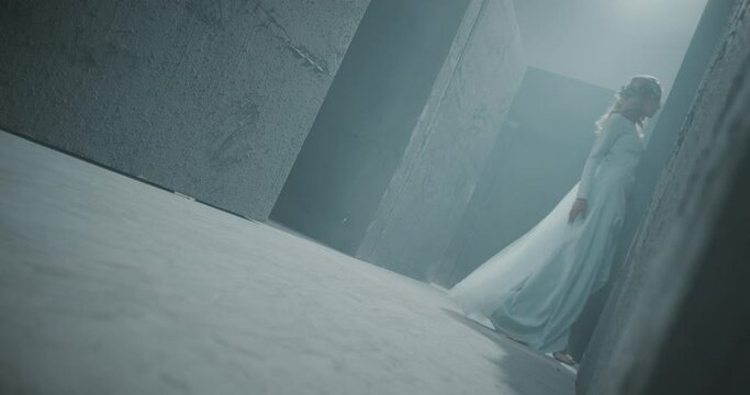 4K Side view of girl walking inside dark maze . Footage of mystic video of bride in labyrinth . Vision of mystical dream . Shot on ARRI ALEXA Cinema Camera in slow motion .