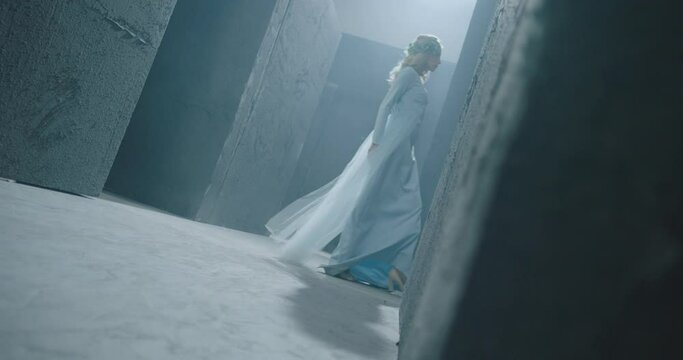 4K Side view of girl walking inside dark maze . Footage of mystic video of bride in labyrinth . Vision of mystical dream . Shot on ARRI ALEXA Cinema Camera in slow motion .