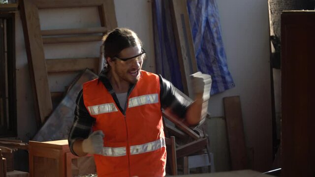 Happy and excited carpenter man celebrate to success with computer laptop with order and good news online . Business Owner wood worker In Workshop