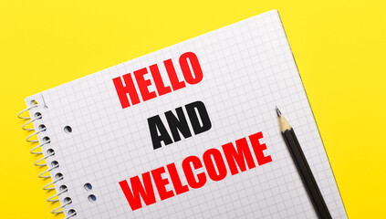 White notebook with inscription HELLO AND WELCOME written in black pencil on a bright yellow background.