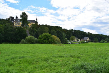Fototapeta na wymiar Ansicht von Schloss Oranienstein aus Aull mit den Wiesen an der Lahn