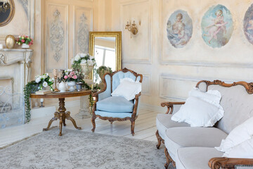 luluxury rich sitting room interior in beige pastel color with antique expensive furniture in baroque style. walls decorated with stucco and frescoes