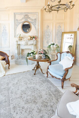 luluxury rich sitting room interior in beige pastel color with antique expensive furniture in baroque style. walls decorated with stucco and frescoes