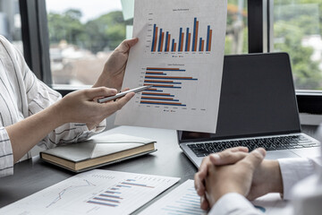 Two businessmen are meeting together on company sales, they are business partners who open the company together, they are brainstorming and analyzing how to manage the company's sales growth.