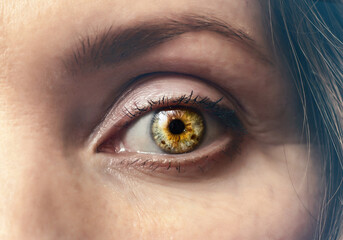 Woman's eye is bright, close-up. Dramatic contrast