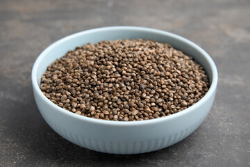 Bowl with hemp seeds on grey table