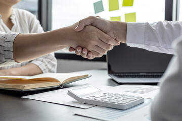Two businessmen shake hands, they are business partners to open a company together, they attend a brainstorming meeting to manage sales growth and join hands after business talks. Management concept.