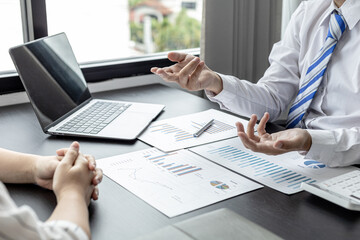 A businessman is explaining to his business partners in detail how to solve a sales fall problem so that they can make joint decisions to manage their sales growth. Company management concept.