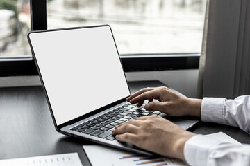 A business man typing on a laptop keyboard, he is using his laptop to type and text with colleagues to discuss his work together. Concept of using technology in communication.