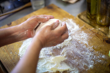 person kneading dough on table