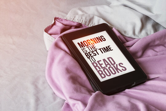 Modern E-reader Electronic Book With Text On Screen - Morning Is The Best Time To Read Books - On Gray And Purple Bed With Sunlight Lens Flare. Tablet With Quote About Reading On Microfiber Bedding