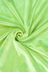 The drapery of green satin. Luxury smooth green silk for background. Fabric rose on the drapery