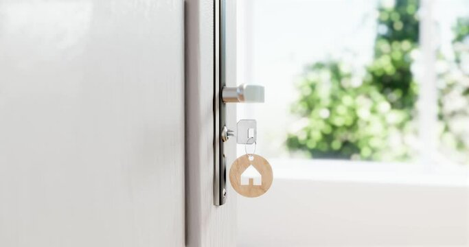 Key in door with house-shaped keychain &ndash; real estate, home ownership or rental investment concept