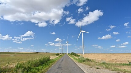 Fototapeta na wymiar Wind turbines and little straight road