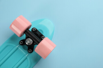 Skateboard on turquoise background, top view. Space for text