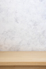 Photo of wood top table and white concrete wall