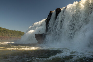Sailing the river. The majestic Mocona waterfalls seen from the boat. The falling white water, rocks and river flowing across the jungle.