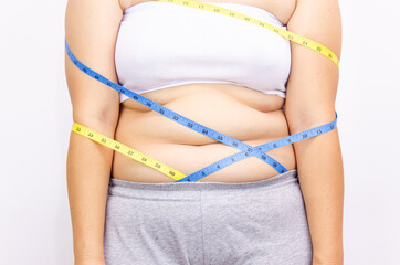 Beautiful fat woman with tape measure She uses her hand to squeeze the excess fat that is isolated on a white background. She wants to lose weight, the concept of surgery and break down fat under the