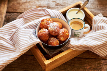 Round curd donuts. Sweet white sauce, fried balls. Side view. Coffee, rustic.