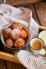 Round curd donuts. Sweet white sauce, fried balls. Side view. Coffee, rustic.