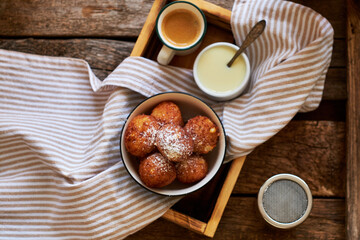 Round curd donuts. Sweet white sauce, fried balls. Top view. Coffee, rustic.