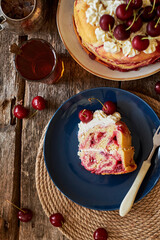 Cherry cake. Yeast bun with cherries and cream. A piece of cake. Top view, wooden background.