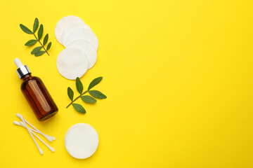 Cotton pads, swabs and makeup removal product on yellow background, flat lay. Space for text