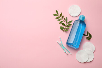 Cotton pads, swabs and makeup removal product on pink background, flat lay. Space for text