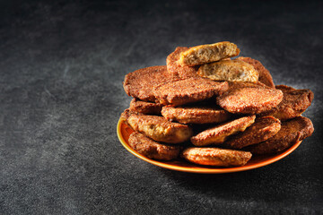 Fried cutlets from fish caviar, close-up. Laid out on an orange plate. Dark background, horizontal orientation. Copy space