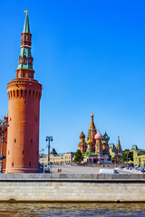 Fototapeta premium Beklemishevskaya Tower of the Moscow Kremlin, Vasilievsky Descent and St. Basil's Cathedral on a sunny summer day - Moscow, Russia, July 2021