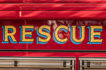 Yellow lettering of rescue on red firetruck