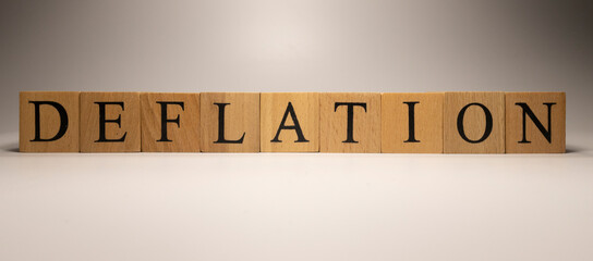 The name Deflation was created from wooden letter cubes. Economics and finance.