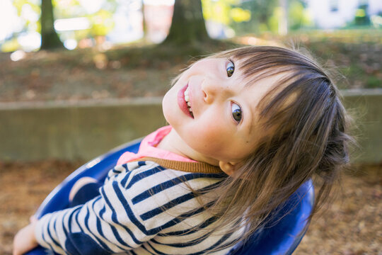 Portrait of a smiling girl in a playground looking over her shoulder