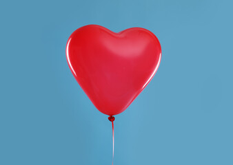 Fototapeta na wymiar Festive heart shaped balloon on light blue background