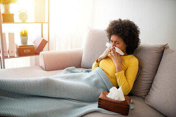 Sick Woman Covered With a Blanket Lying in Bed With High Fever and a Flu, Resting at Living Room. She Is Exhausted and Suffering From Flu. Sick Woman With Runny Nose Lying in Bed.