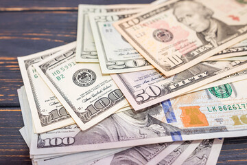 different dollars on a wooden background.